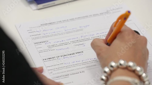 Close up of woman hands writing with a pen and filling a form photo