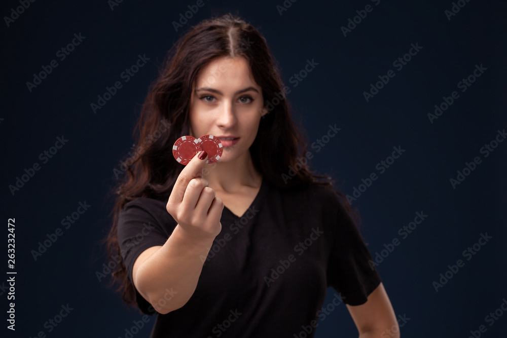 Curly hair brunette is posing with red gambling chips in her hands. Poker concept on a black background. Casino. Curly hair brunette is posing with red gambling chips in her hands. Poker concept on a black background. Casino.
