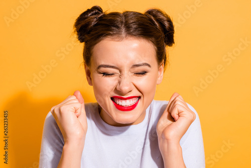 Close-up portrait of her she nice-looking attractive lovely cheerful cheery optimistic teen girl holding fists isolated over bright vivid shine yellow background