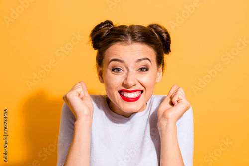 Close-up portrait of her she nice-looking attractive winsome fascinating lovely cheerful cheery optimistic glam girl holding fists hope luck isolated over bright vivid shine yellow background