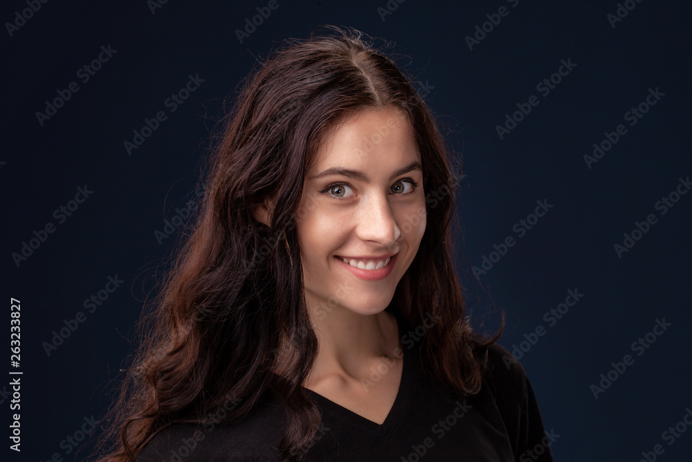 Close-up portrait of a beautiful brunette with curly hair and professional make-up posing on a black background. Close-up portrait of a beautiful brunette with curly hair and professional make-up posing on a black background.