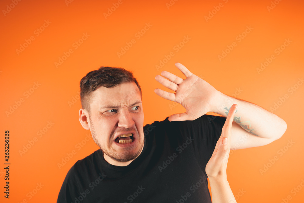 Man getting slapped on orange background Unhappy scared man getting slapped standing on orange background Man getting slapped on orange background Unhappy scared man getting slapped standing on orange background