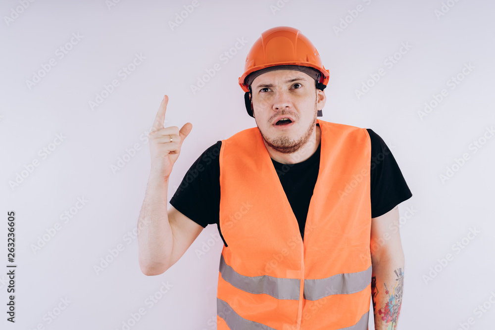 Man in working uniform on white background Portrait of young male in bright orange protective hardhat and vest looking at camera on white background Man in working uniform on white background Portrait of young male in bright orange protective hardhat and vest looking at camera on white background