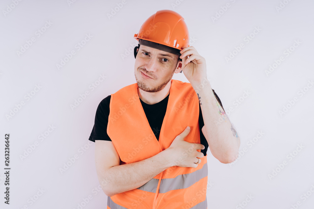 Man in working uniform on white background Portrait of young male in bright orange protective hardhat and vest looking at camera on white background Man in working uniform on white background Portrait of young male in bright orange protective hardhat and vest looking at camera on white background