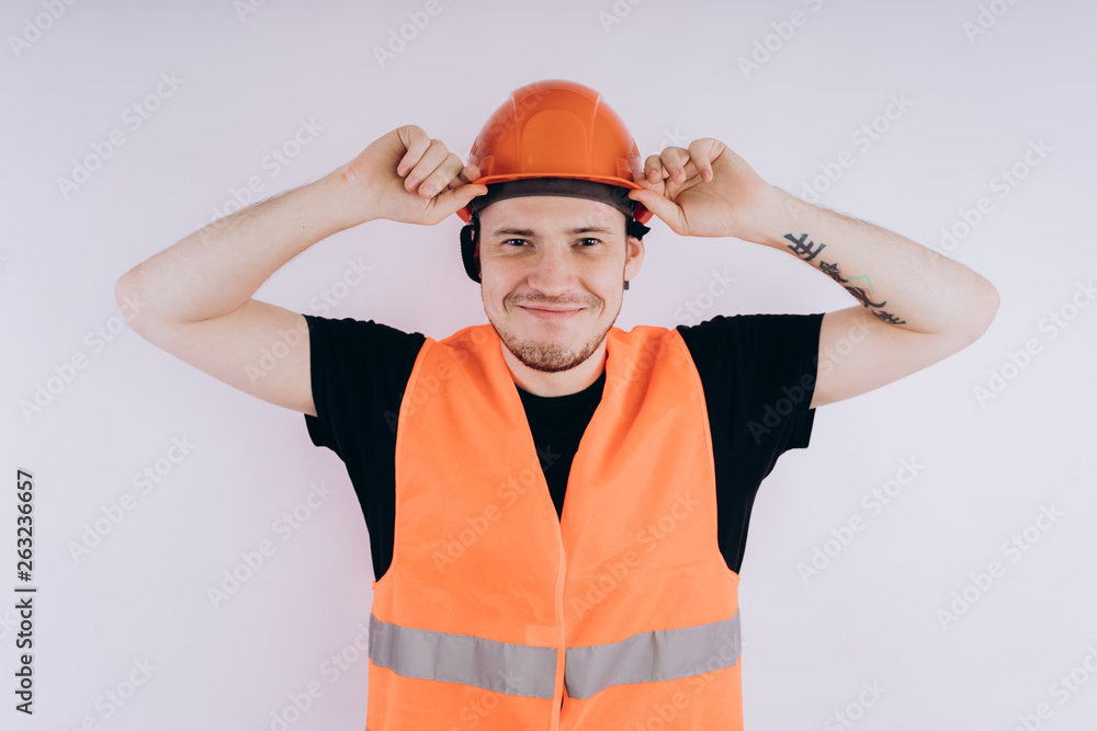 Man in working uniform on white background Portrait of young male in bright orange protective hardhat and vest looking at camera on white background Man in working uniform on white background Portrait of young male in bright orange protective hardhat and vest looking at camera on white background