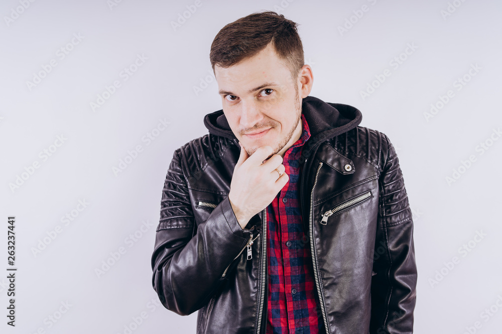 Man in trendy jacket on white background Portrait of young male in leather jacket zipping up and smiling at camera on white background