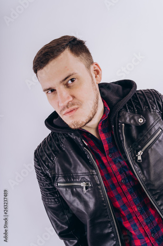 Man in trendy jacket on white background Portrait of young male in leather jacket zipping up and smiling at camera on white background