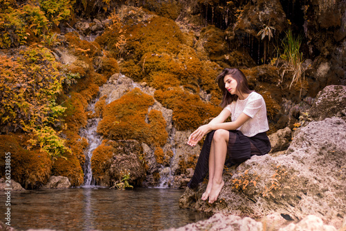 Beautiful girl posing in river, fairy fast forest in autumn. Beauty, fashion. Spa, healthcare. Tropical vacation. Natural pool.