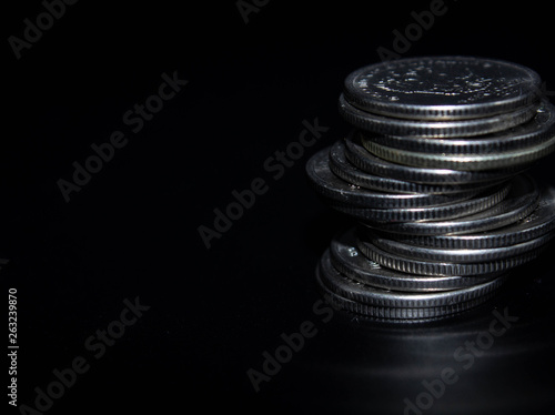 Coins stack on black background in concept wall and strong money.