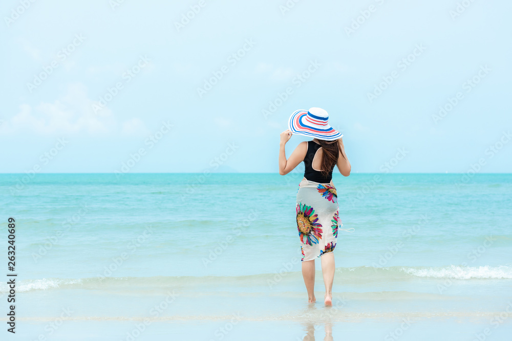 Summer Holiday. Lifestyle woman chill holding big white hat and wearing bikini fashion summer trips walking on the sandy ocean beach. Happy woman enjoy and relax vacation. Lifestyle Travel Summer Holiday. Lifestyle woman chill holding big white hat and wearing bikini fashion summer trips walking on the sandy ocean beach. Happy woman enjoy and relax vacation. Lifestyle Travel