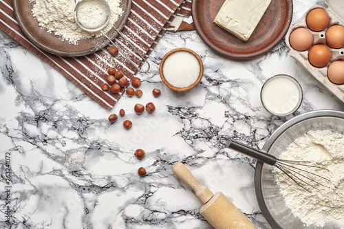 Close-up shot. Top view of a baking ingredients and kitchenware on the marble table background.