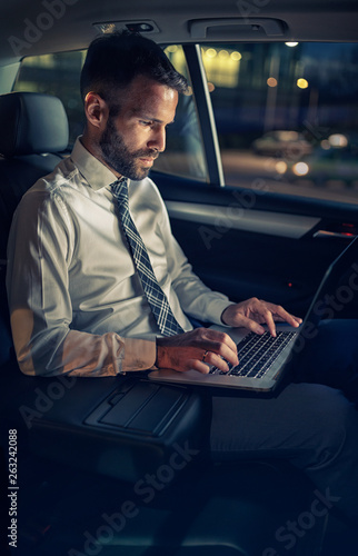 success businessman working late in car on laptop. © luckybusiness