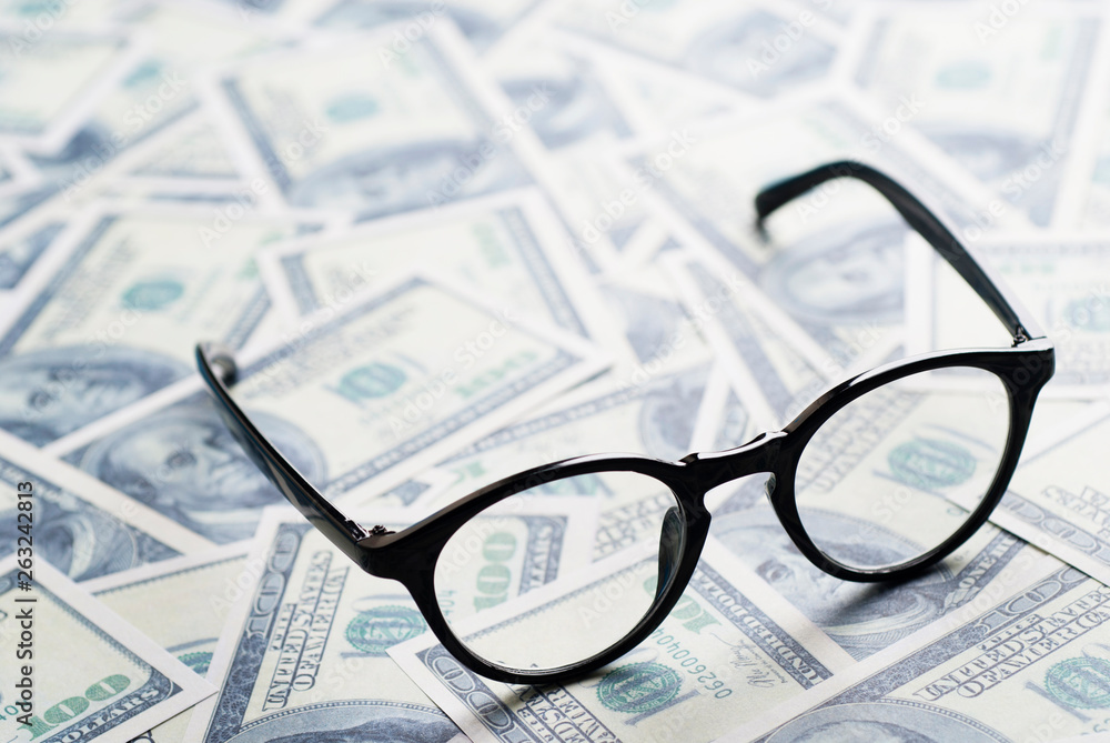 Making money. Wealth and power. Eyeglasses on dollar banknotes. Making money. Wealth and power. Eyeglasses on dollar banknotes.