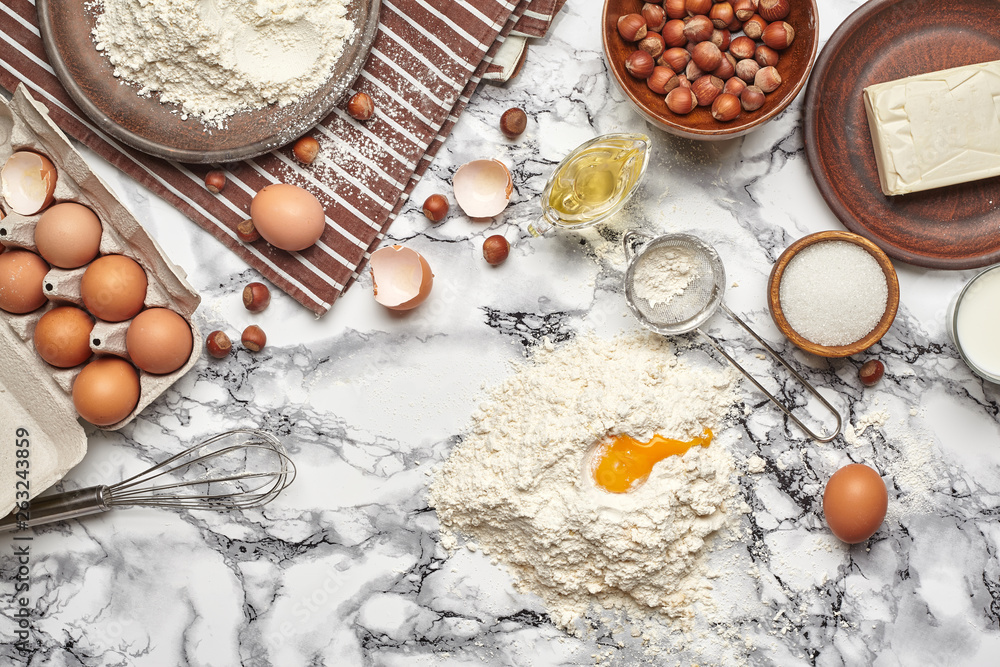 Close-up shot. Top view of a baking ingredients and kitchenware on the marble table background. Close-up shot. Top view of a baking ingredients and kitchenware on the marble table background.