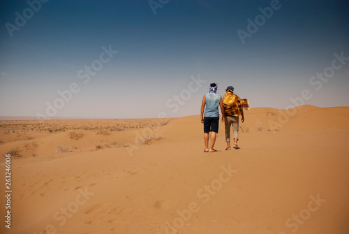 A shot of two men walking away together bare feet on the endless