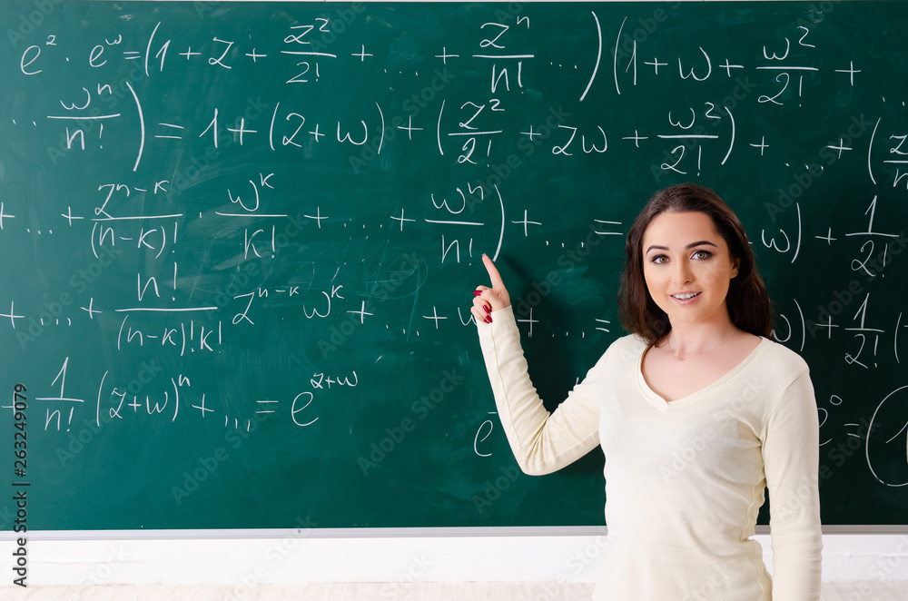 Young female math teacher in front of chalkboard Young female math teacher in front of chalkboard