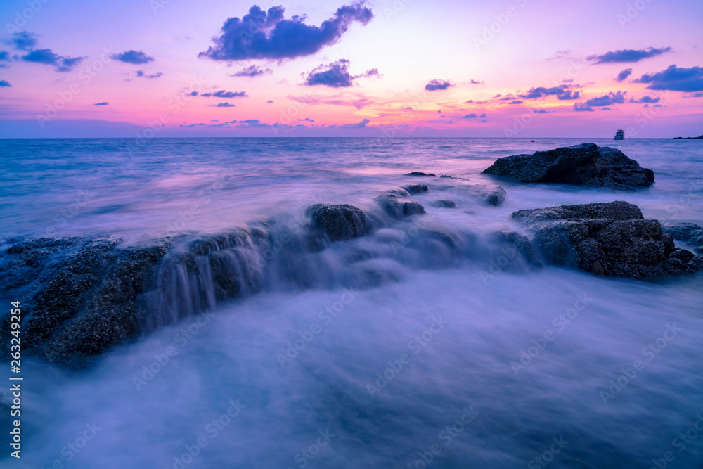 Long exposure image of Dramatic sky and wave seascape with rock in sunset scenery background Long exposure image of Dramatic sky and wave seascape with rock in sunset scenery background