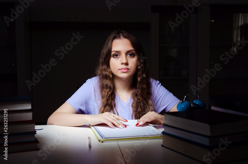 Young female student preparing for exams late at home 