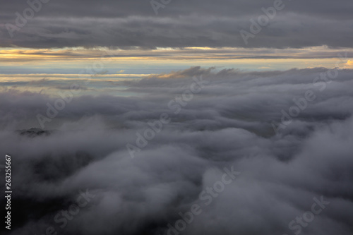 Abstract photograph above the clouds, sea of clouds effect, flying through the sky, aerial view, white puffy clouds and blue sky. Low pressure front atmospheric effect, cloudscape, cloudy weather