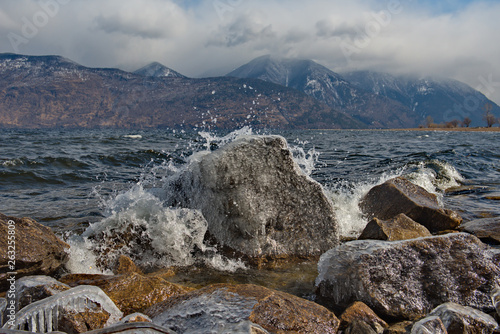 The beating waves on the rocks. Russia. mountain Altai. Early spring in the South of lake Teletskoye.