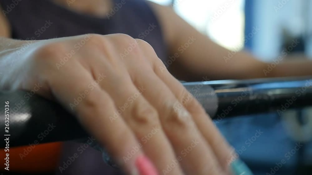 Close up hands of muscular sports woman working out with weight. Fit woman doing weight lifting exercises in gym. Slow motion Close up hands of muscular sports woman working out with weight. Fit woman doing weight lifting exercises in gym. Slow motion