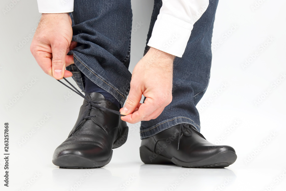 Man tying shoelaces on classic shoes Man tying shoelaces on classic shoes