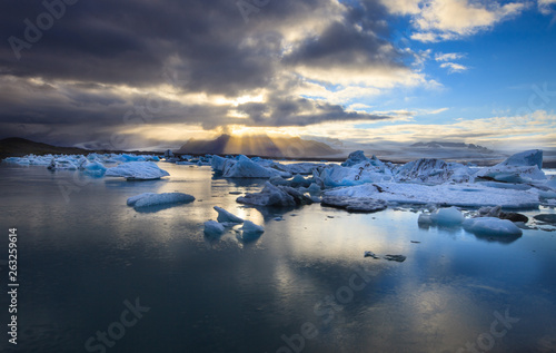 Dramatic a sunset with mirror water with blue iceberg pieces in Jokulsarlon lagoon, Iceland. © Natalia