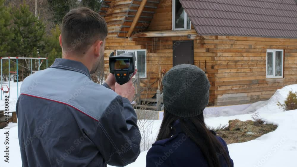 Portrait of the worker of the house which is carrying out an inspection by the thermal imager. To show to the customer problem places. Energy saving. Portrait of the worker of the house which is carrying out an inspection by the thermal imager. To show to the customer problem places. Energy saving.