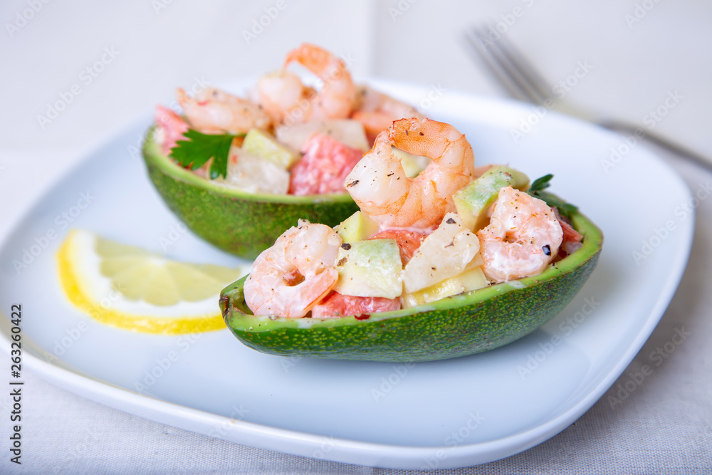 Salad with shrimps, avocado, pineapple and grapefruit in half avocado. Selective focus, close-up. Salad with shrimps, avocado, pineapple and grapefruit in half avocado. Selective focus, close-up.