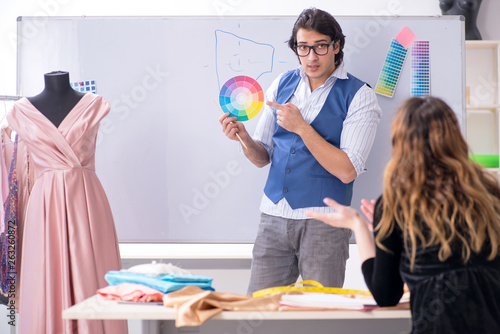 Young male tailor teaching female student 