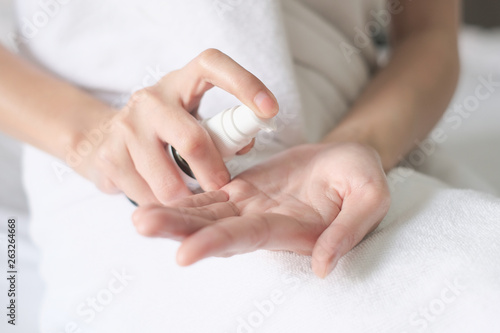 Asia woman sitting on bed and applying cream lotion on Hand  Beauty Concept.