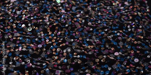 Texture of black cloth with colorful sequins. Close-up.