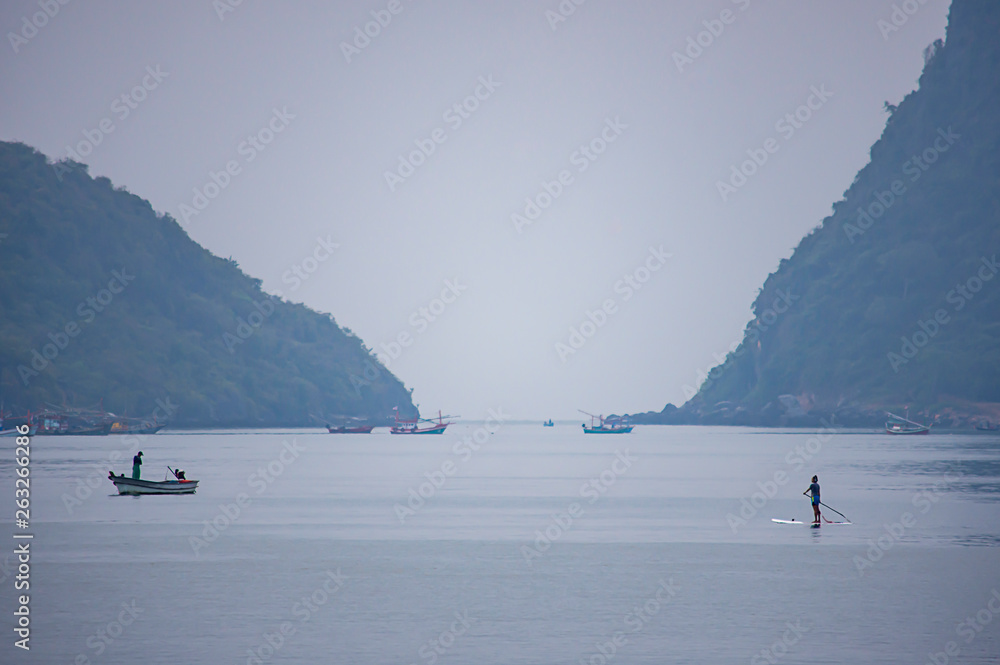 Fototapeta premium Tourists on surf boards in the sea at Prachuap Bay in Thailand.