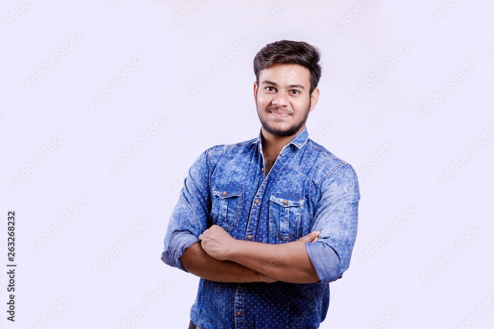 Handsome young Indian man standing with hands folded isolated over white background Handsome young Indian man standing with hands folded isolated over white background