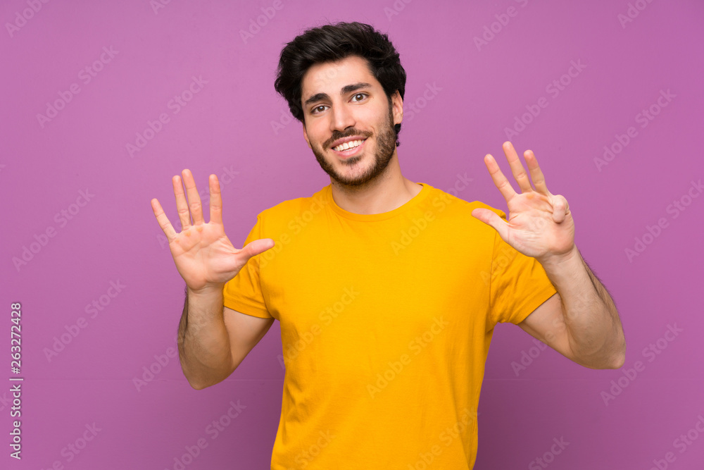 Naklejka premium Handsome over isolated purple wall counting nine with fingers