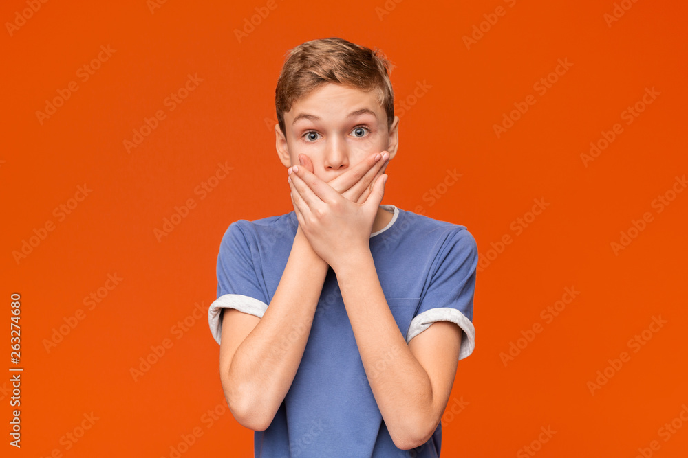 Portrait of stunned boy on orange studio background Portrait of stunned boy on orange studio background