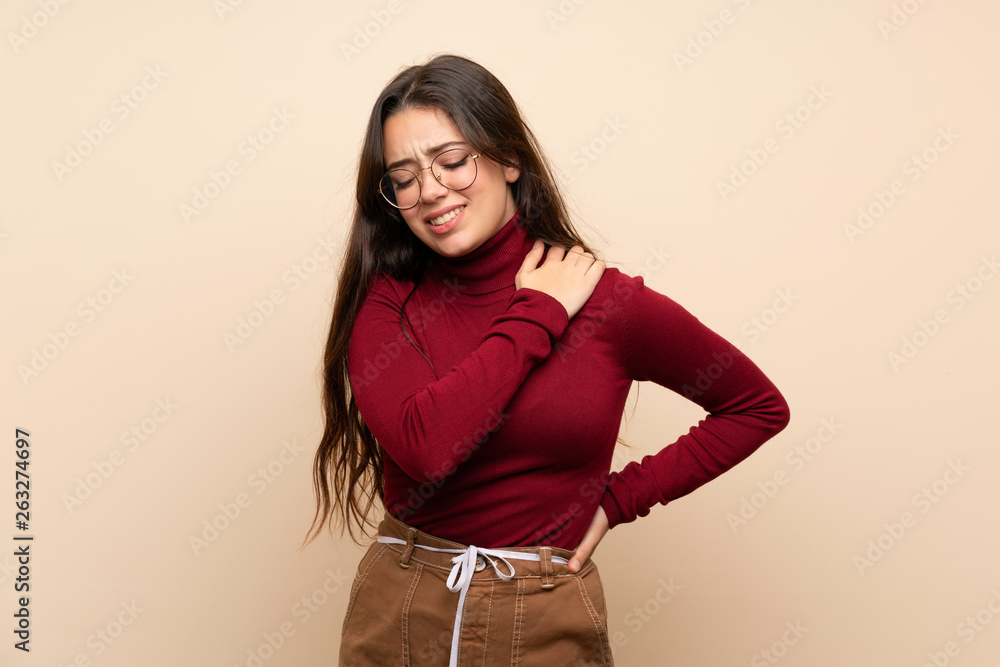 Teenager girl with glasses suffering from pain in shoulder for having made an effort Teenager girl with glasses suffering from pain in shoulder for having made an effort