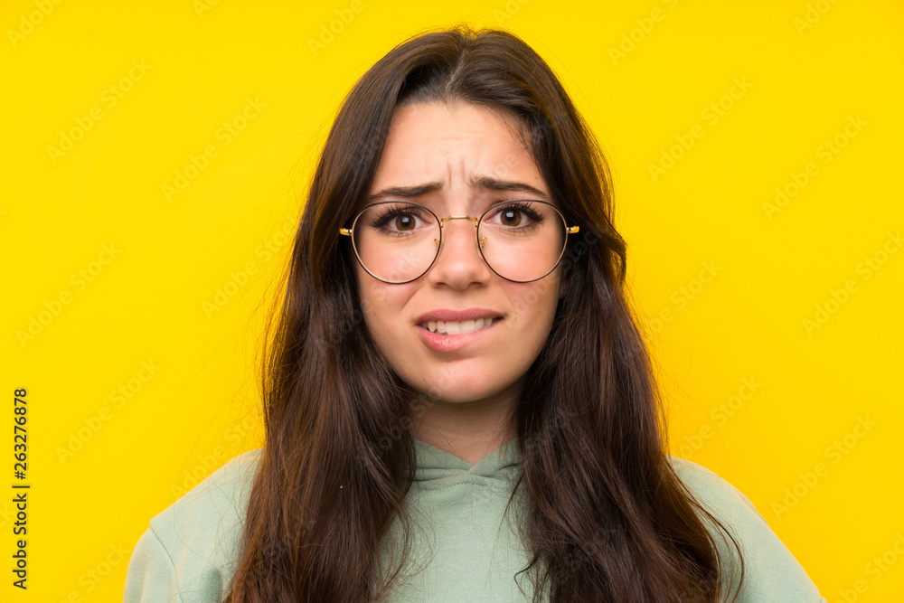 Obraz premium Teenager girl with sweatshirt having doubts and with confuse face expression
