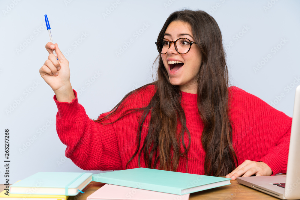 Teenager student girl studying in a table thinking Teenager student girl studying in a table thinking