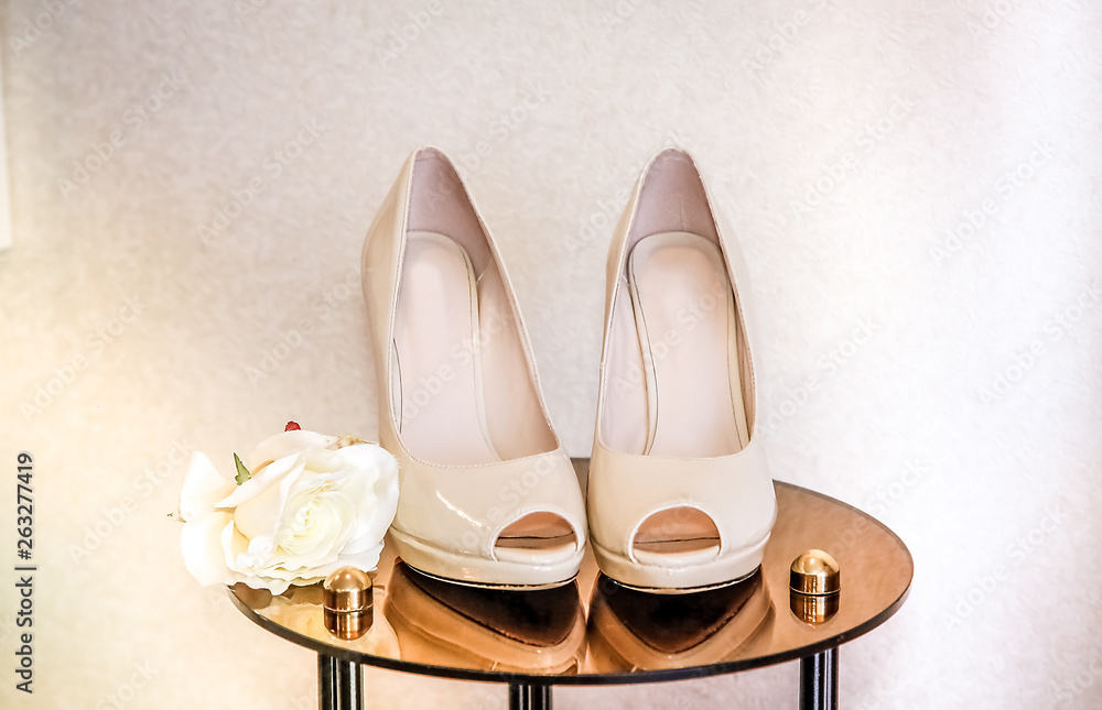 Wedding shoes with high heels are on the mirror table Wedding shoes with high heels are on the mirror table