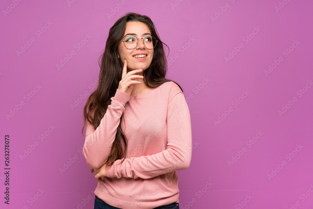 Teenager girl over purple wall thinking an idea while looking up Teenager girl over purple wall thinking an idea while looking up