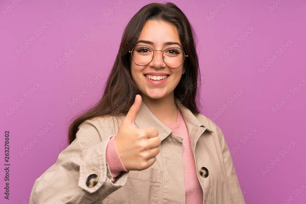 Teenager girl over purple wall giving a thumbs up gesture Teenager girl over purple wall giving a thumbs up gesture