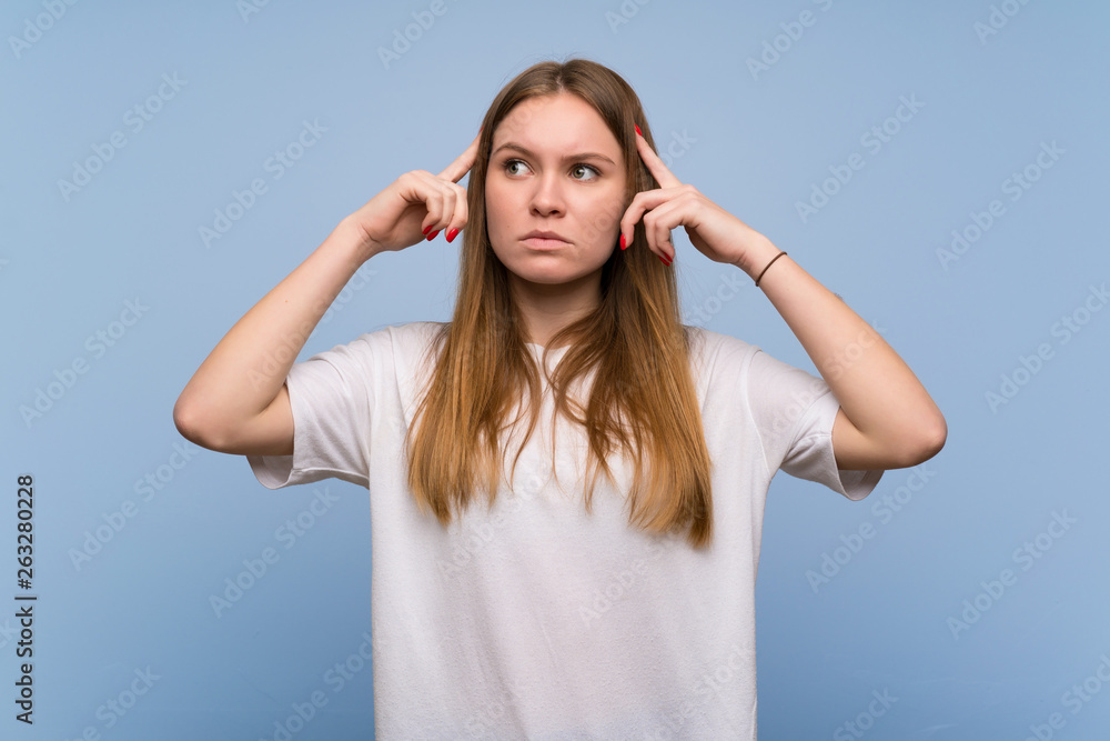 Young woman over blue wall having doubts and thinking Young woman over blue wall having doubts and thinking