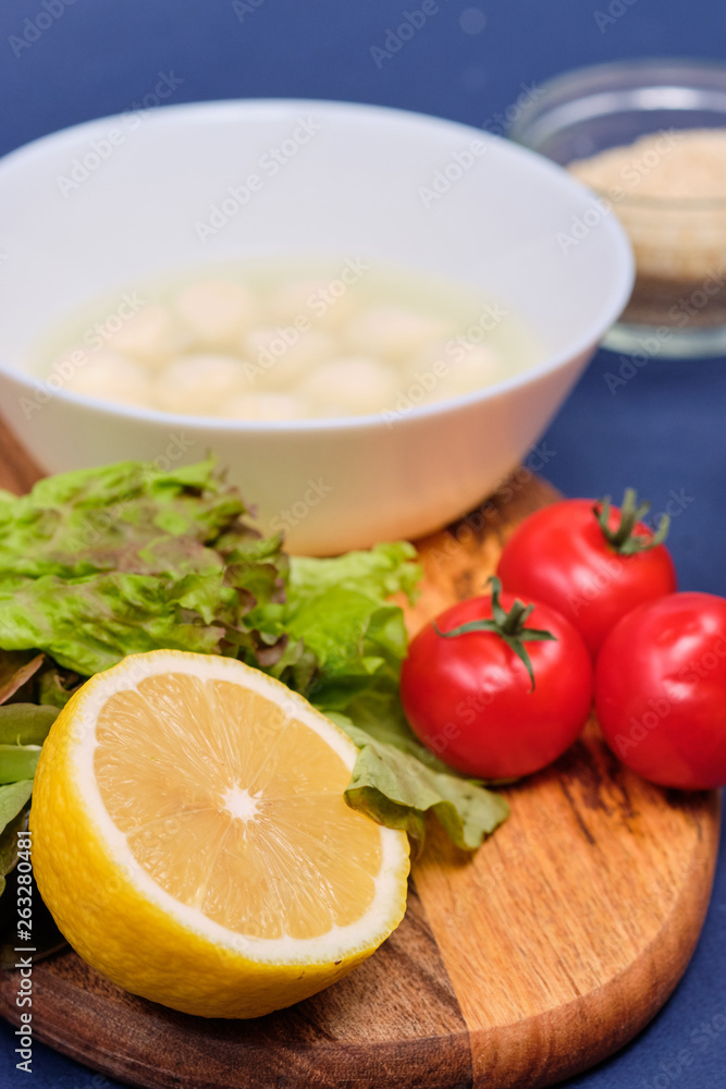 fresh vegetables and a bowl of salad with mozzarella on a blue background. Caprese salad . Lettuce, cherry tomatoes, mozzarella, fresh vegetables and a bowl of salad with mozzarella on a blue background. Caprese salad . Lettuce, cherry tomatoes, mozzarella,