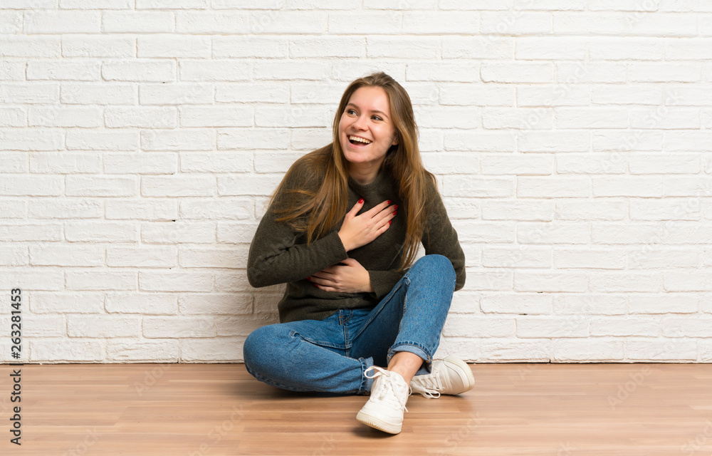 Young woman sitting on the floor smiling a lot Young woman sitting on the floor smiling a lot