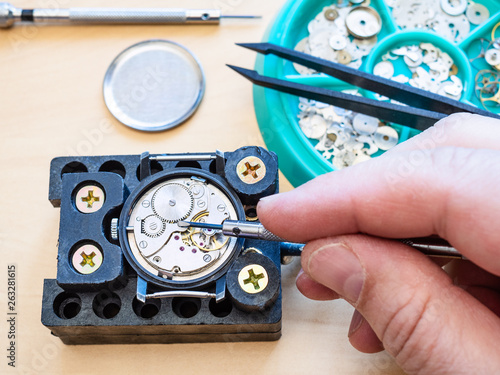 watchmaker fixes clockwork of watch by screwdriver