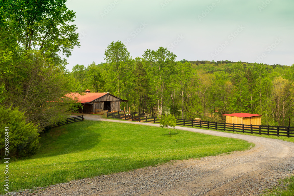 A red-roofed barn on the farm in the spring. A red-roofed barn on the farm in the spring.