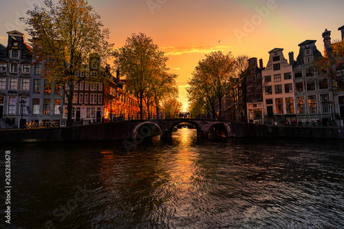 Sunset on the Amsterdam houses and canal reflected on the water of the canal, Amsterdam, Netherlands