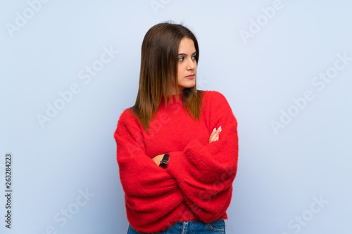 Young woman over isolated blue wall portrait © luismolinero