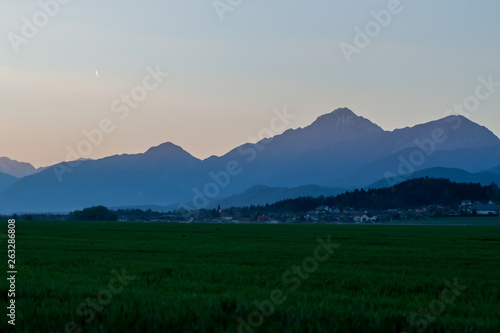 beautiful Alps over green field evening landscape © chechotkin